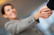 Welcoming business woman giving a handshake and smiling